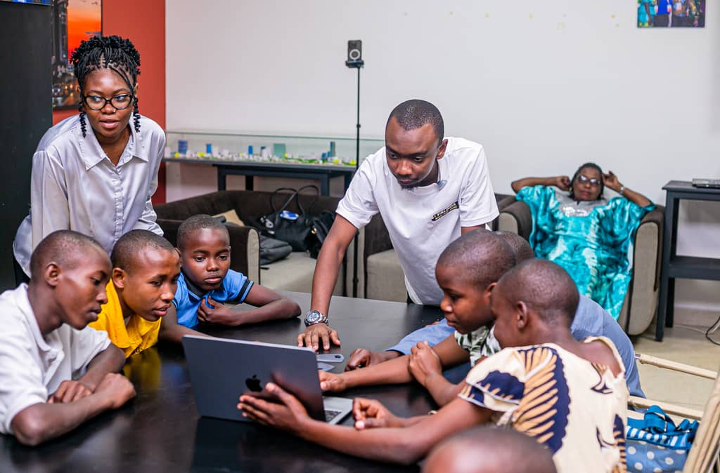 A mentor helping learners on a tablet